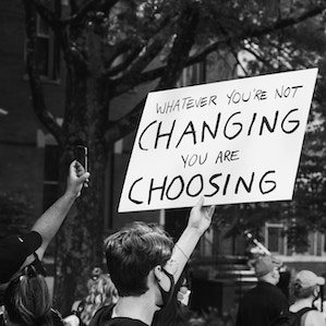 Protest sign: Whatever you're not changing you are choosing