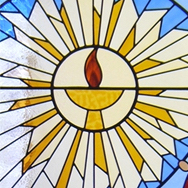 Stained Glass window of a chalice surrounded by a starburst