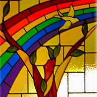 Stained glass window of a tree with a rainbow behind it